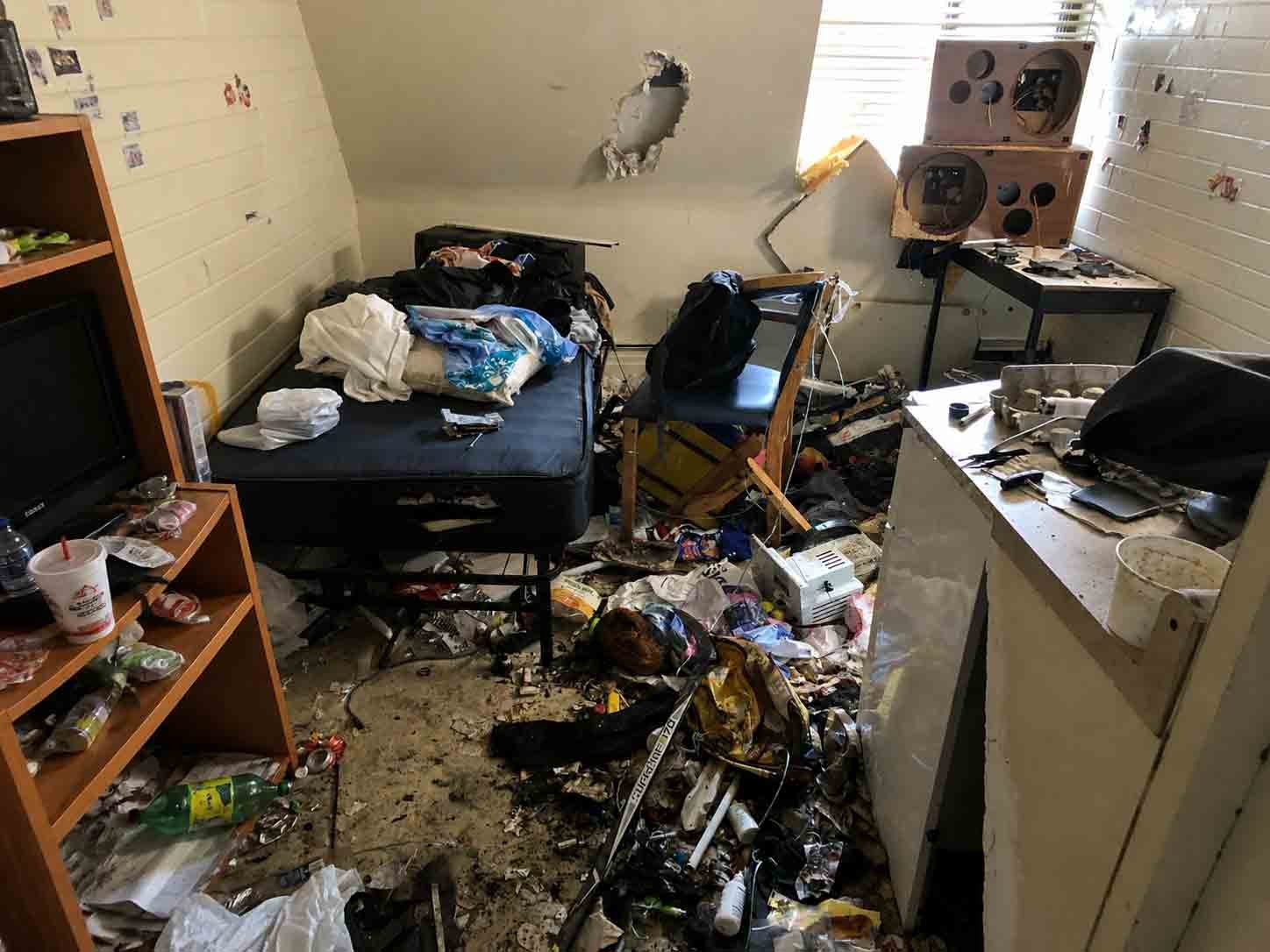 Cluttered room with furniture, trash, and unwanted items before junk removal by Turbo Haul Disposal