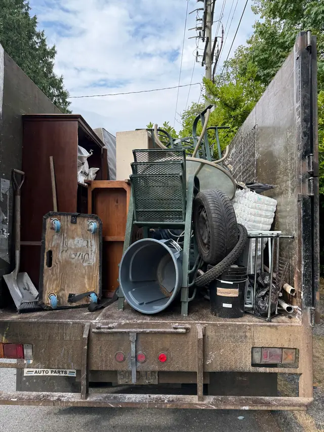 Mixed household junk and bulky items loaded into a removal truck